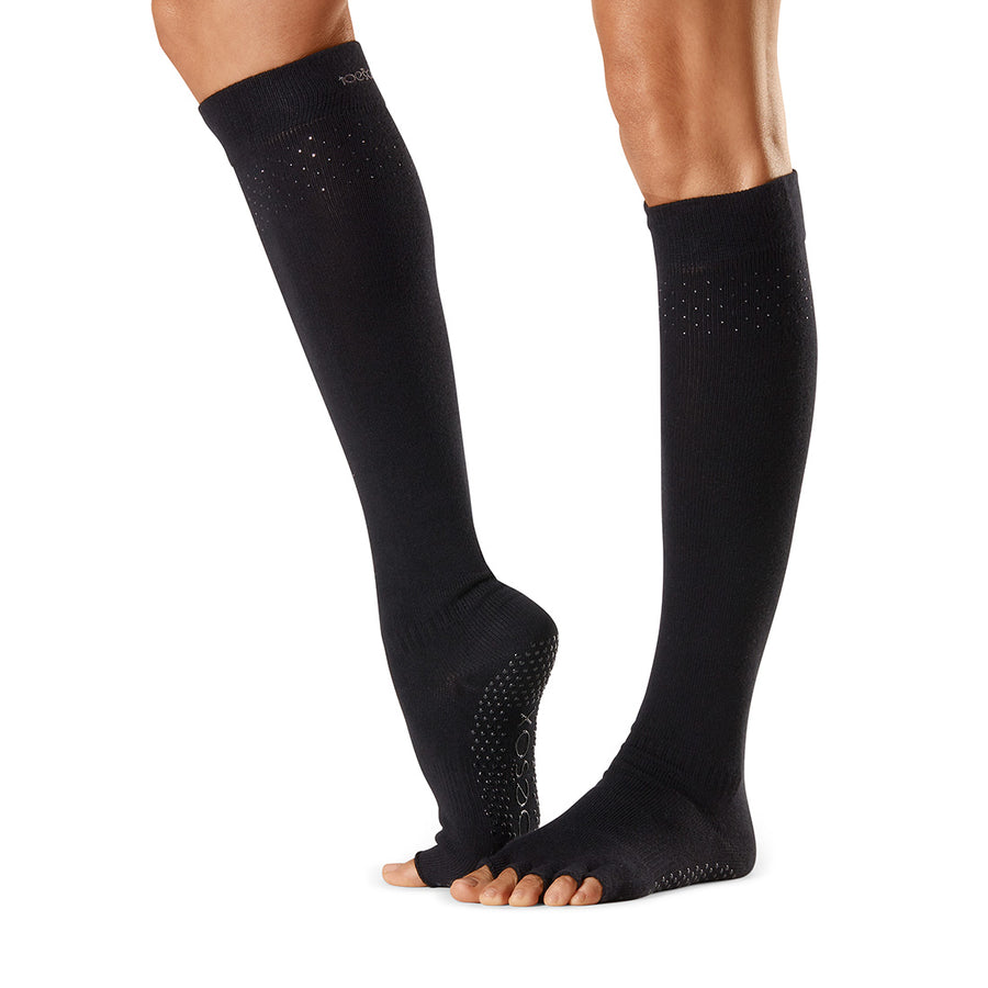 Feet with yoga toe separator socks on white background Stock